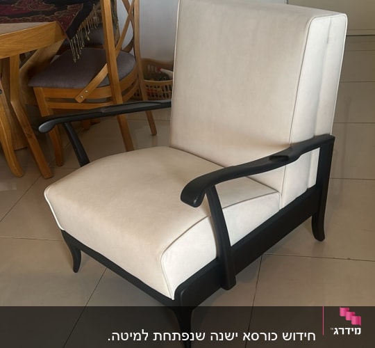 כורסה מרופדת בבד בהיר עם מסגרת עץ כהה
